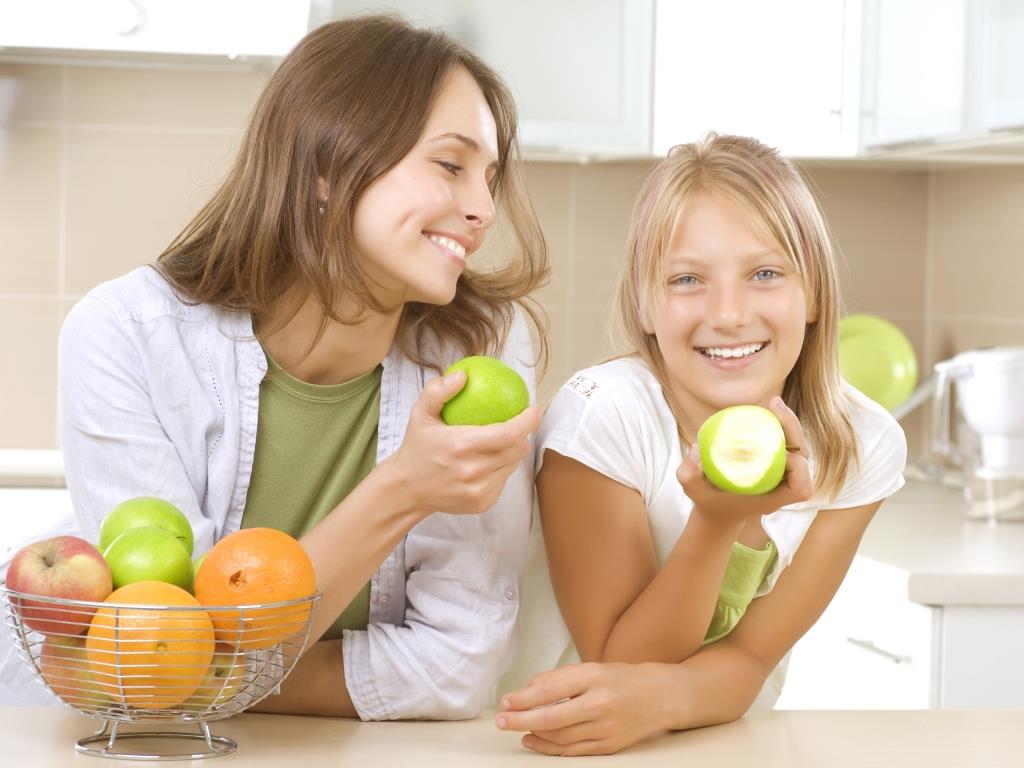 Happy Family Mother with her Daughter eating Healthy food. Diet. Healthy Eating Concept